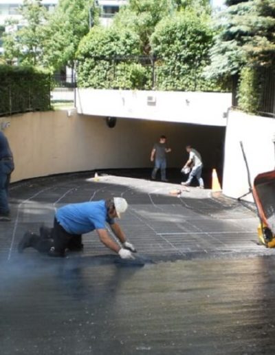 Mastic asphalt being installed over heating cables in a parking garage ramp