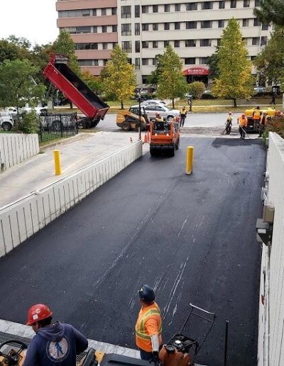 Asphalt being installed over heating cables in a parking garage ramp